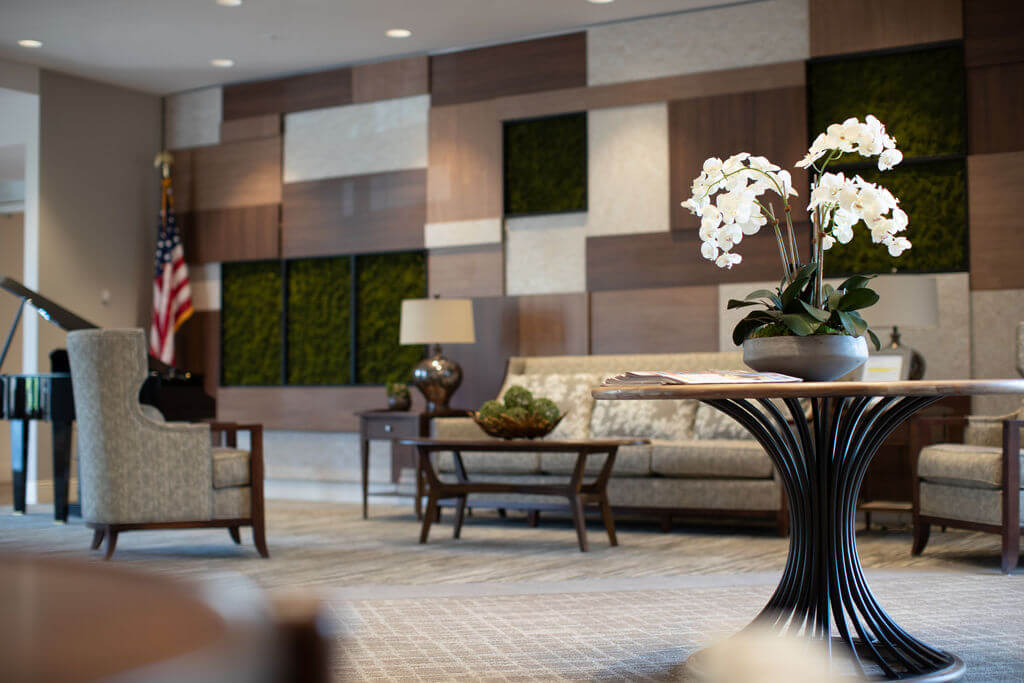 A light-filled common room with seating and a fireplace