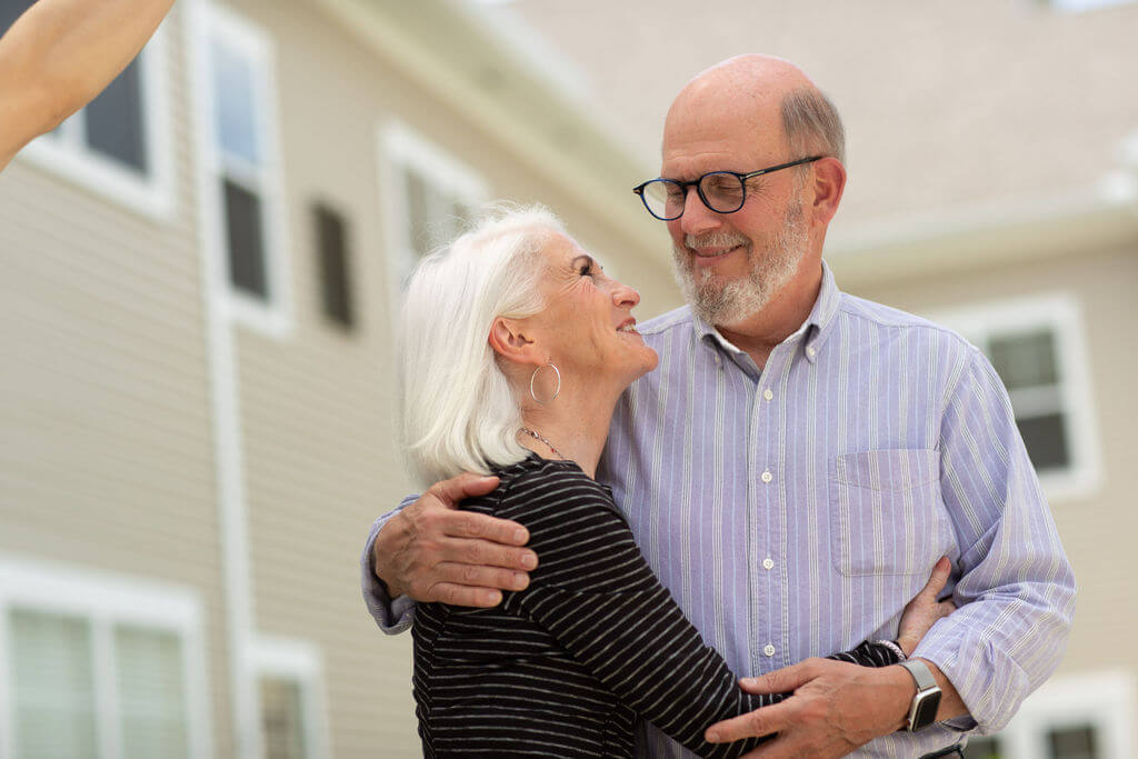 A couple outside a Vista Springs community, arm in arm
