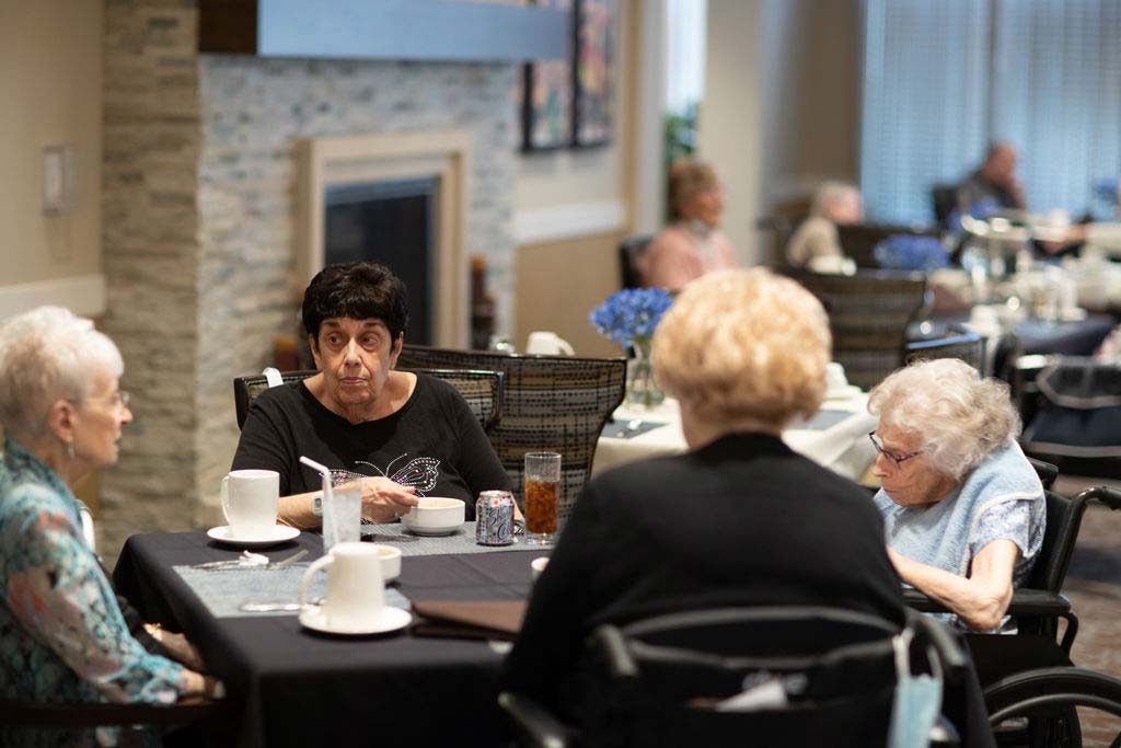 Members and a Contributor talking over coffee in the community bistro