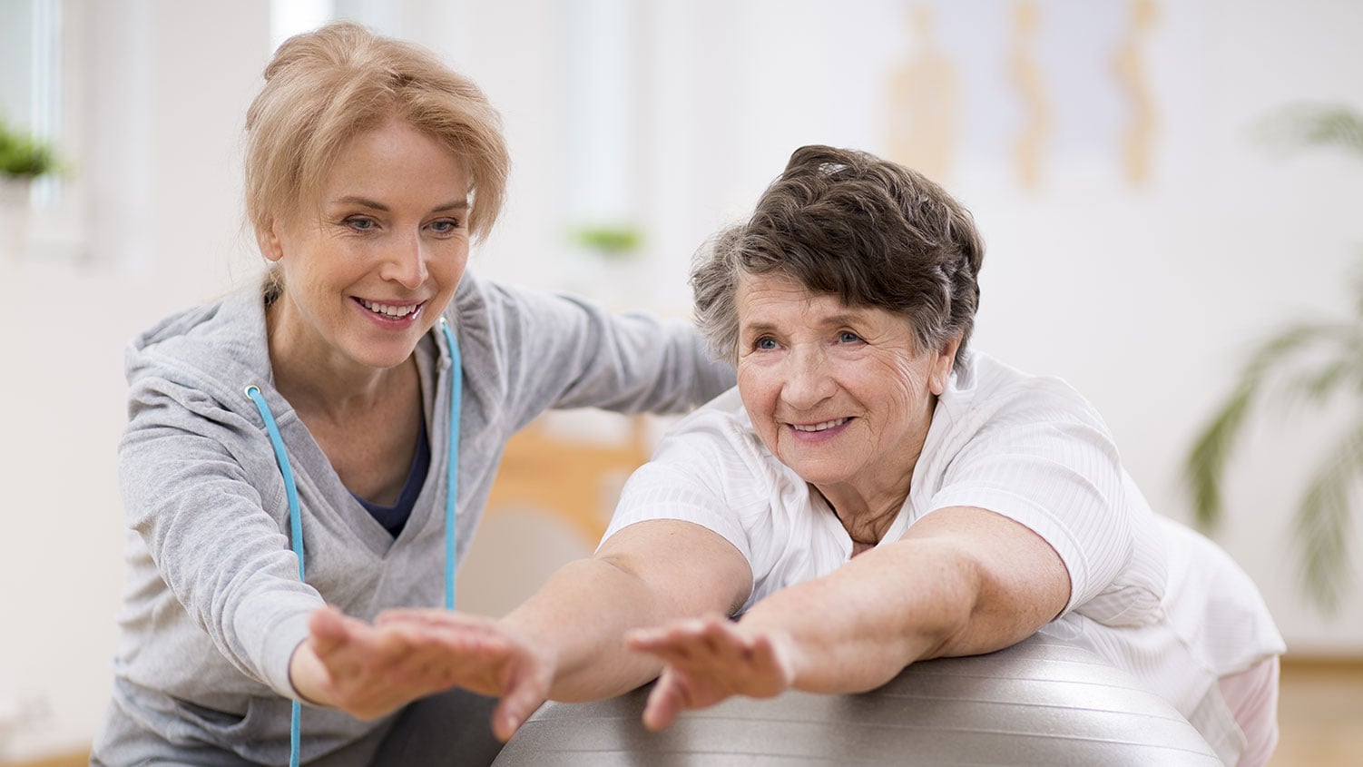 A therapist guiding a Member through stretching exercises