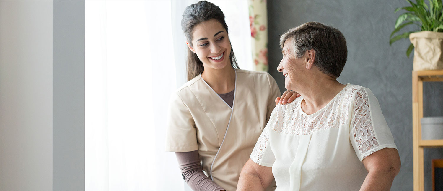 A care team member talking with a Member beside a sunlit window