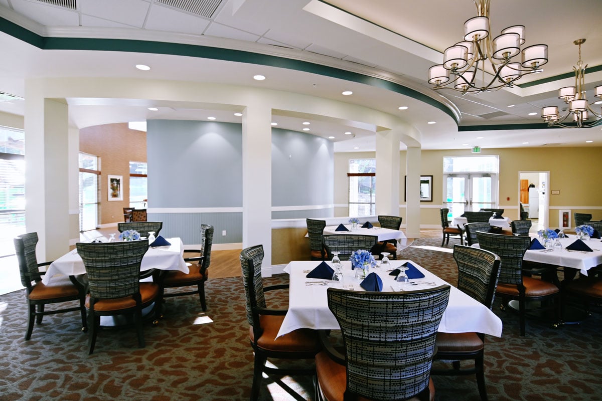 The main dining room, tables set under a chandelier
