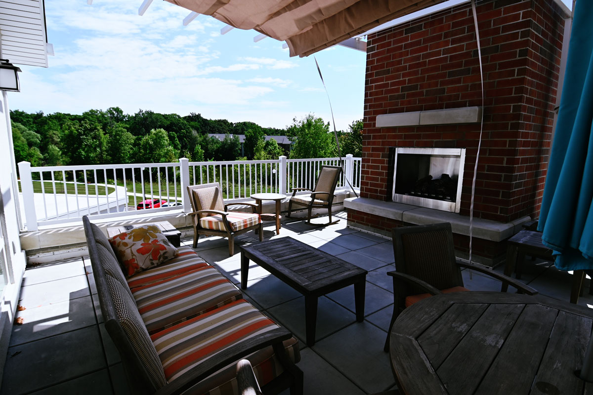 A covered terrace with lounge seating above the water